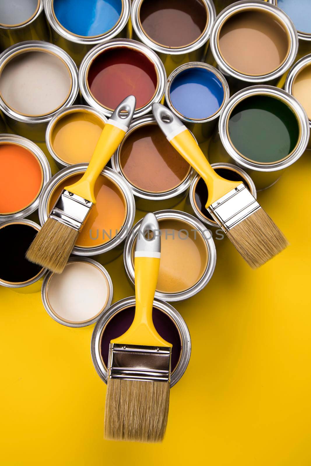 Tin cans with paint, brushes and bright palette of colors