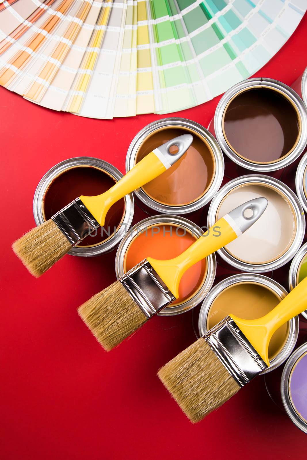 Tin cans with paint, brushes and bright palette of colors