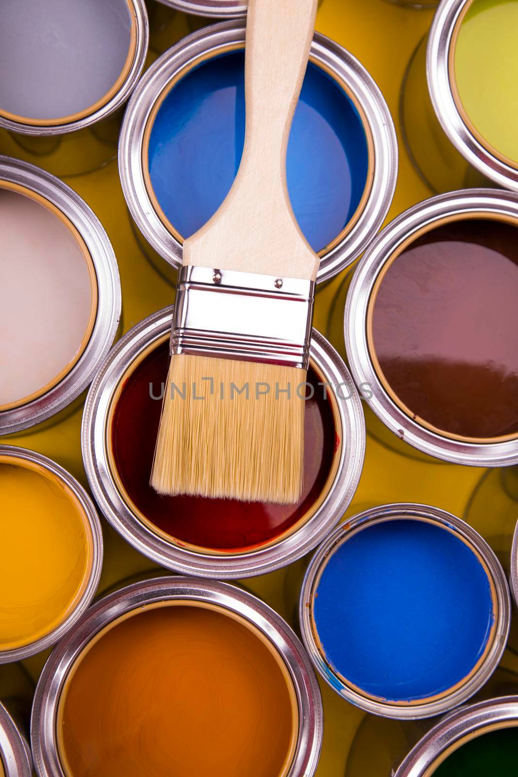 Tin cans with paint, brushes and bright palette of colors