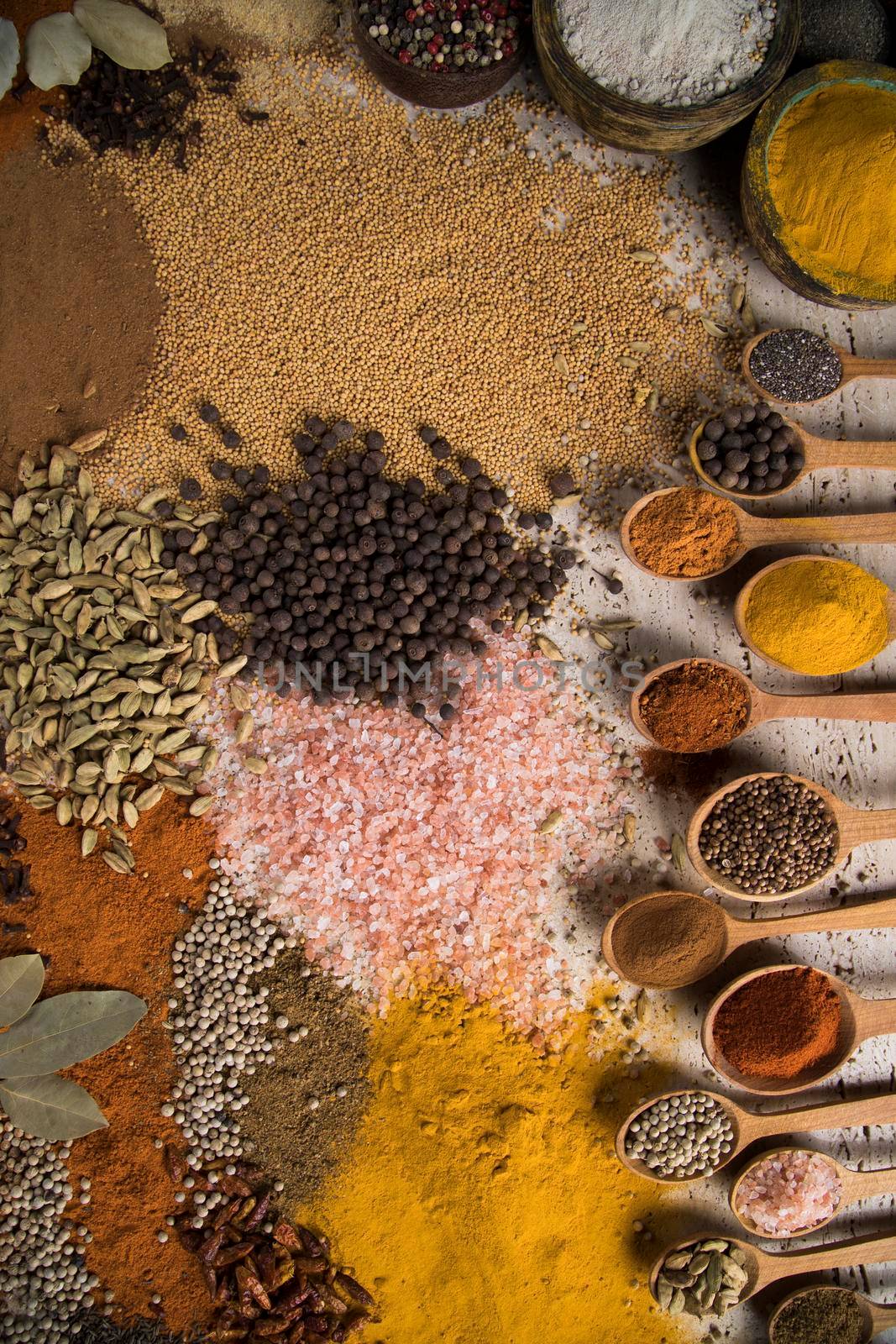 Variety of spices and herbs on kitchen table by JanPietruszka