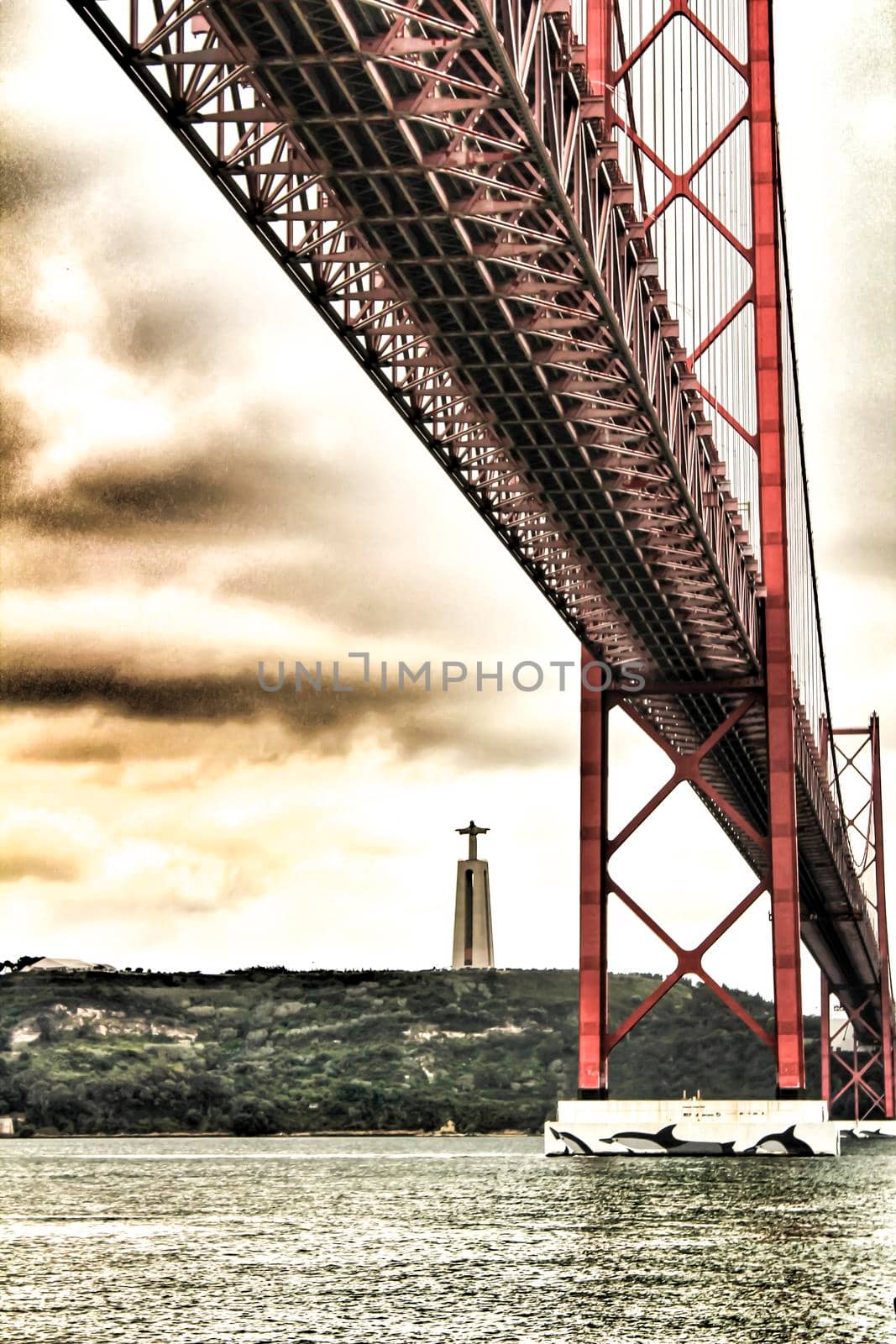 Banks of the river Tagus in Lisbon in Spring on a cloudy day. Beautiful 25th April bridge structure.
