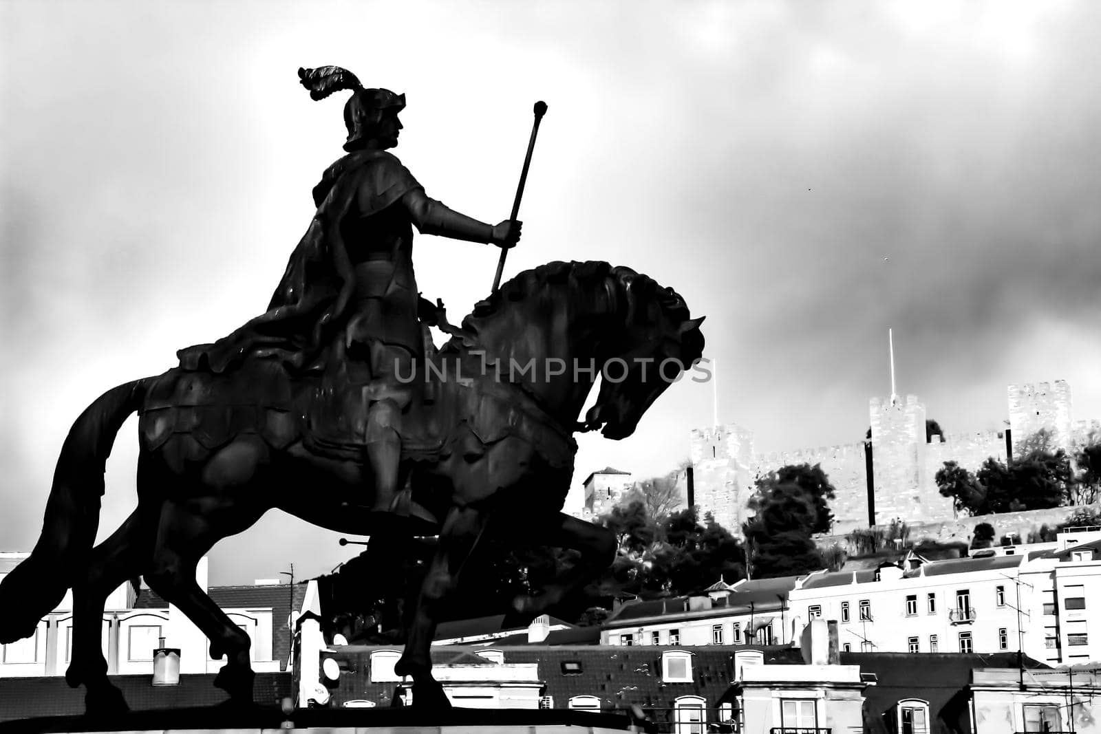 Equestrian statue of Joao I of Portugal in Figueira square in Lisbon. Saint George castle in the background.