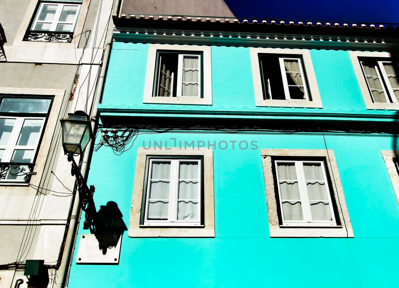 Old colorful and beautiful facades with vintage streetlight in Lisbon streets in Spring.