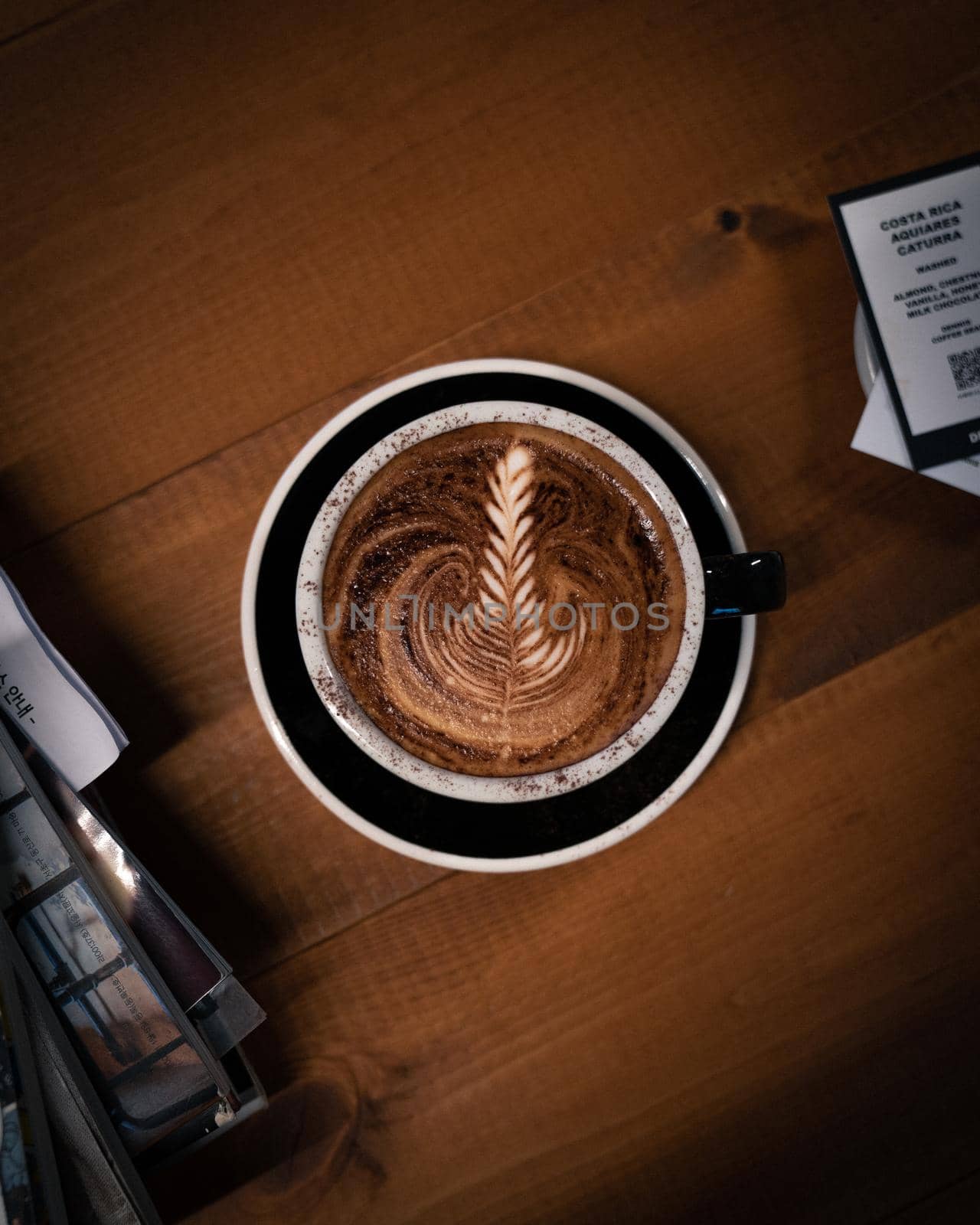 Directly above shot of coffee with latte art on wooden table by uphotopia