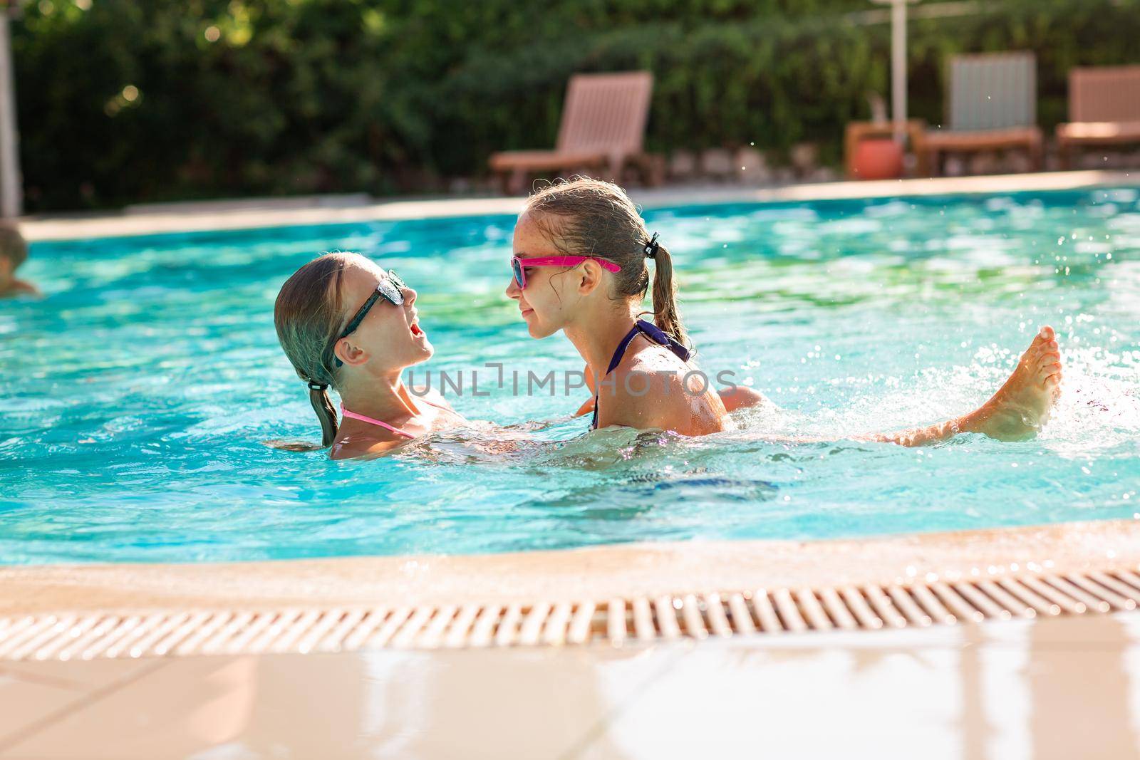 Happy beautiful girls having fun at the pool at the resort