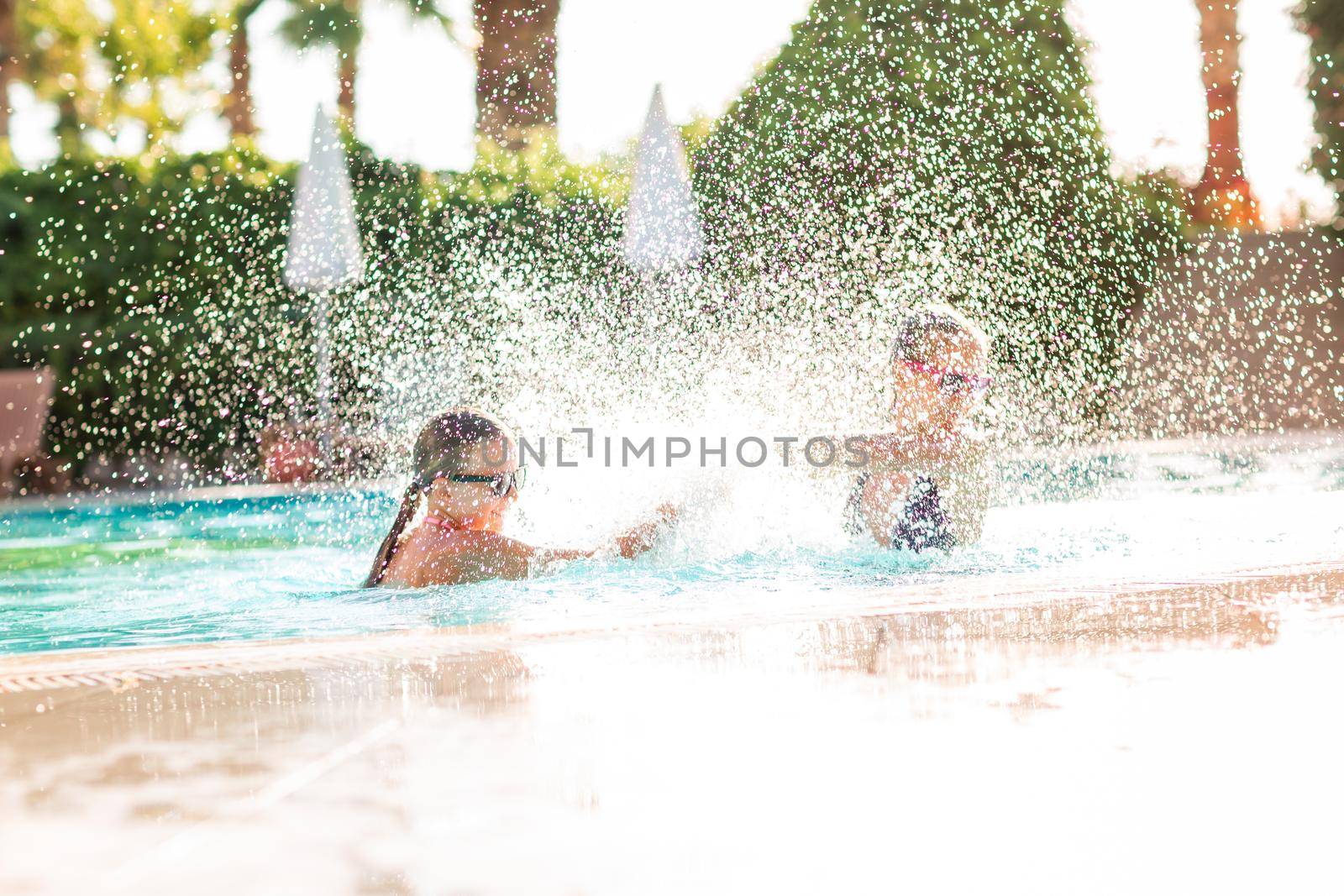 Happy beautiful girls having fun at the pool at the resort