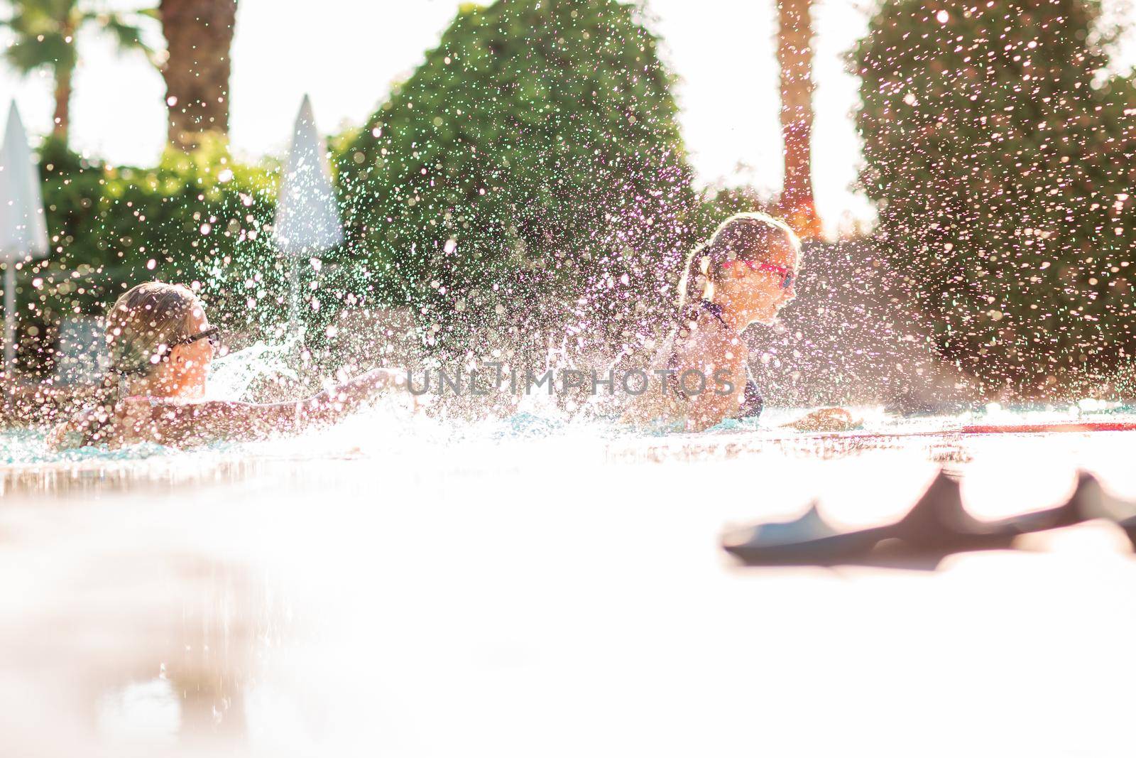 Happy beautiful girls having fun at the pool at the resort