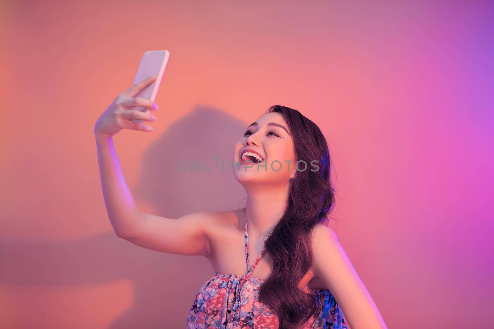 Young woman taking selfie photo on smartphone looking camera laughing happy. 