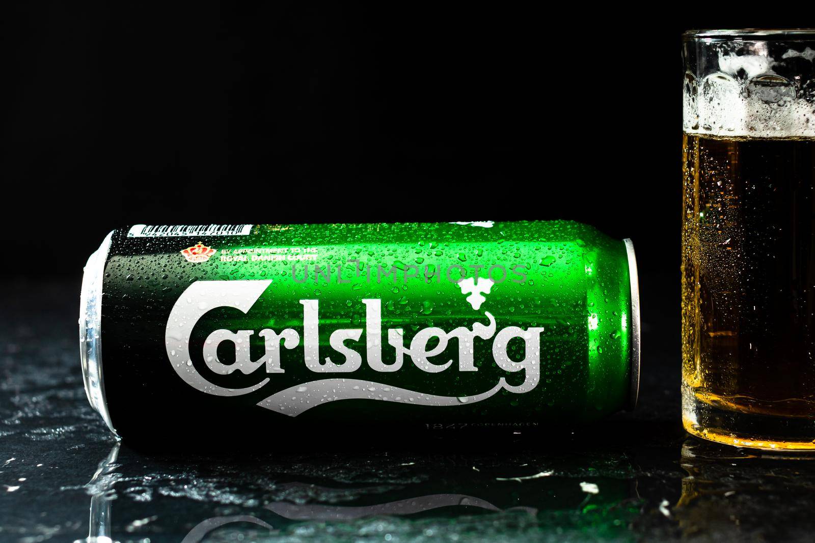 Can of Carlsberg beer and beer glass on dark background. Illustrative editorial photo shot in Bucharest, Romania, 2021 by vladispas