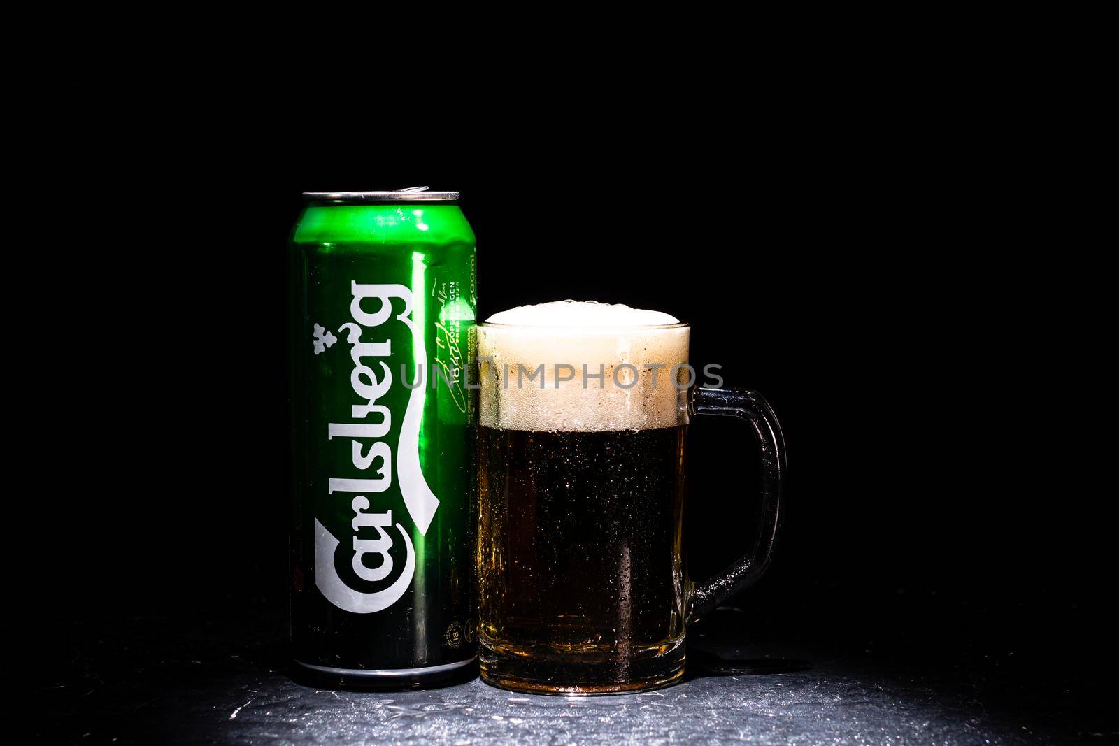 Can of Carlsberg beer and beer glass on dark background. Illustrative editorial photo shot in Bucharest, Romania, 2021 by vladispas