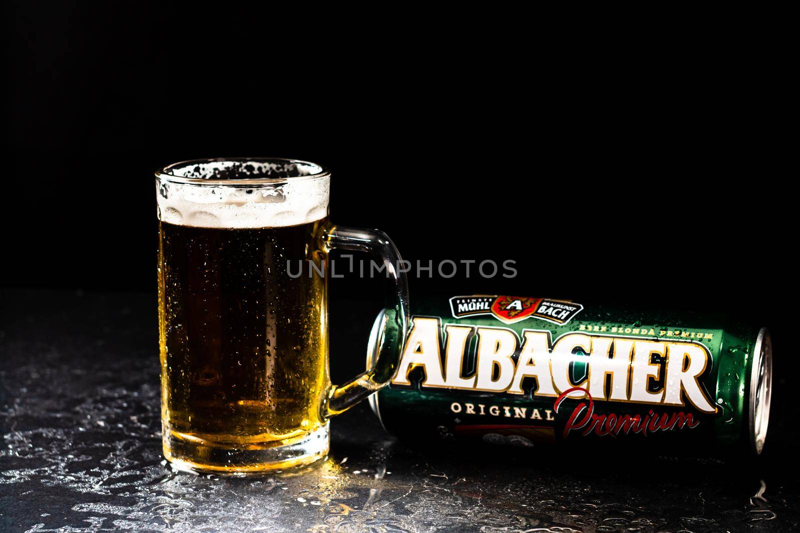 Can of Albacher beer and beer glass on dark background. Illustrative editorial photo shot in Bucharest, Romania, 2021 by vladispas