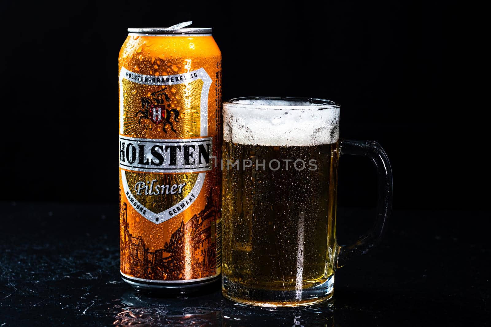 Can of Holsten beer and beer glass on dark background. Illustrative editorial photo shot in Bucharest, Romania, 2021