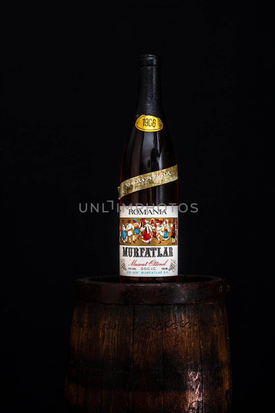 Vintage Murfatlar wine bottle on wooden barrel with dark background. Illustrative editorial photo Bucharest, Romania, 2021