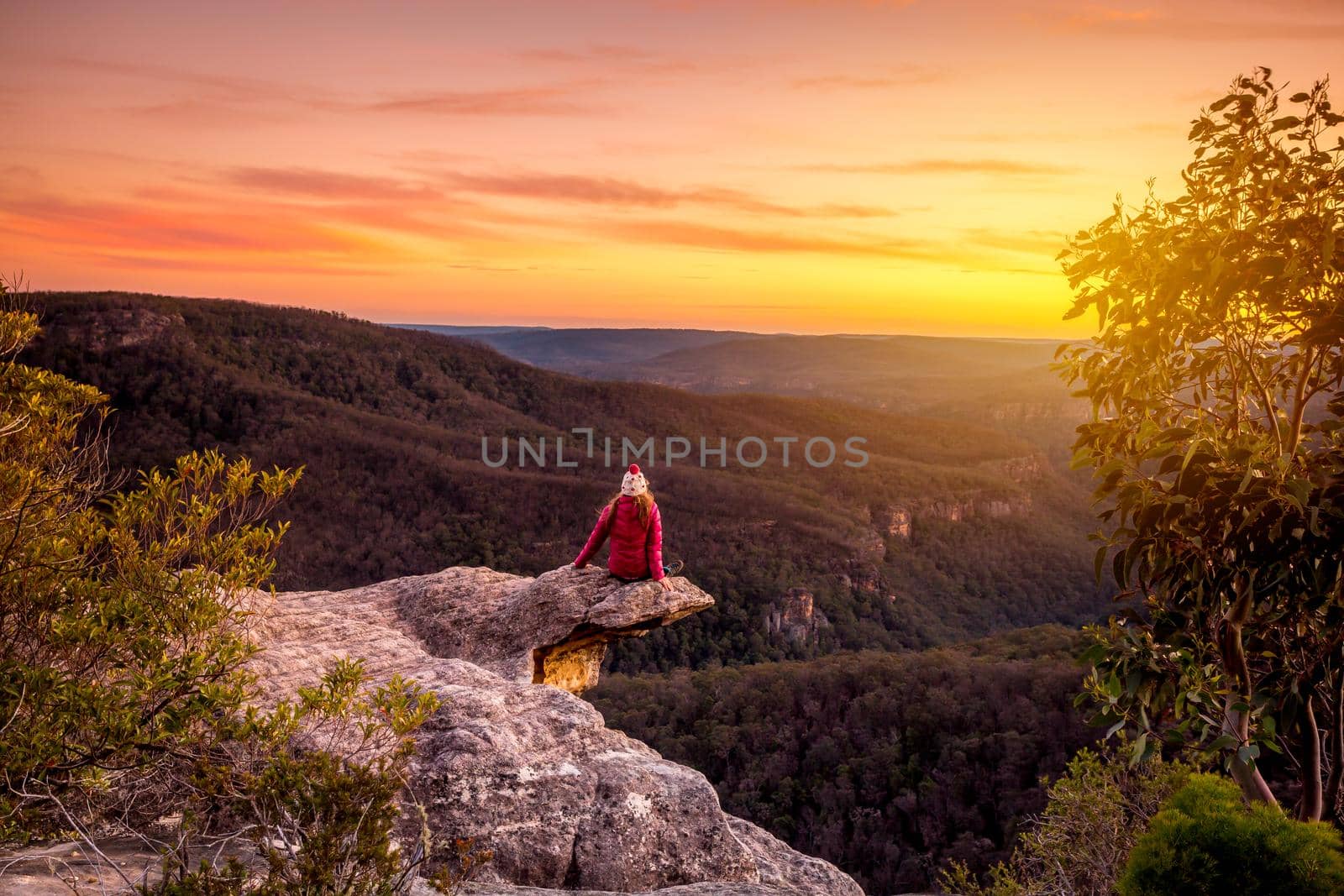 Woman watching sunset over mountains landscape in southern New South Wales, Australia