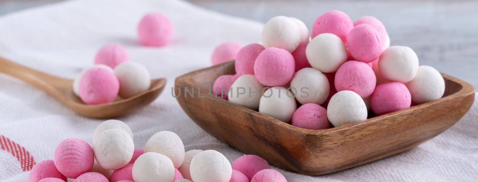 Raw red and white tangyuan glutinous rice dumpling balls on wooden table background for Winter solstice festival food.