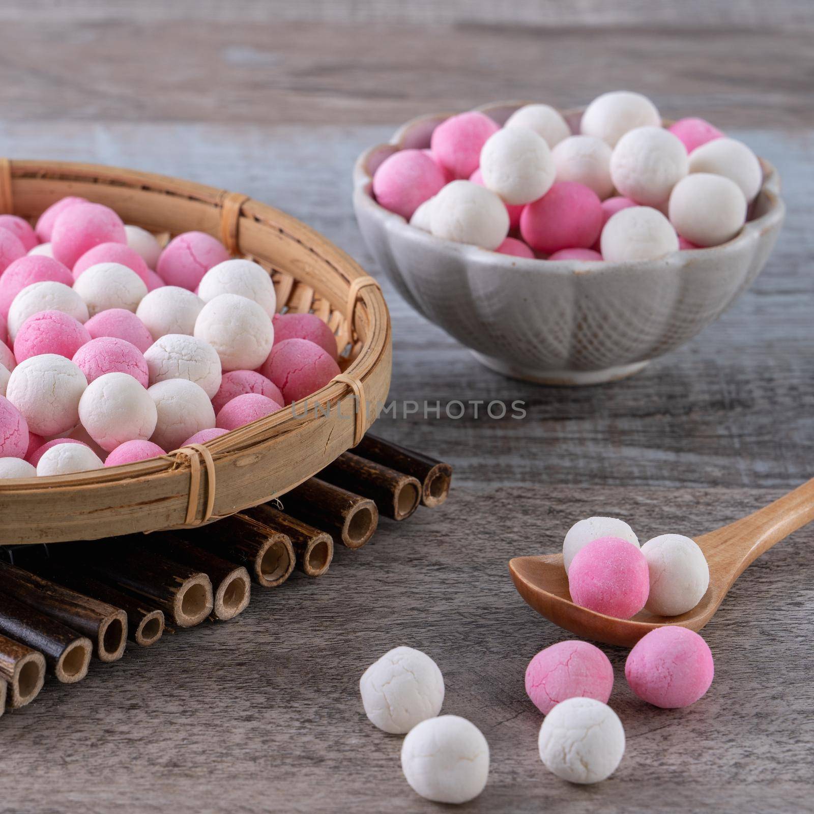 Raw red and white tangyuan glutinous rice dumpling balls on wooden table background for Winter solstice festival food.