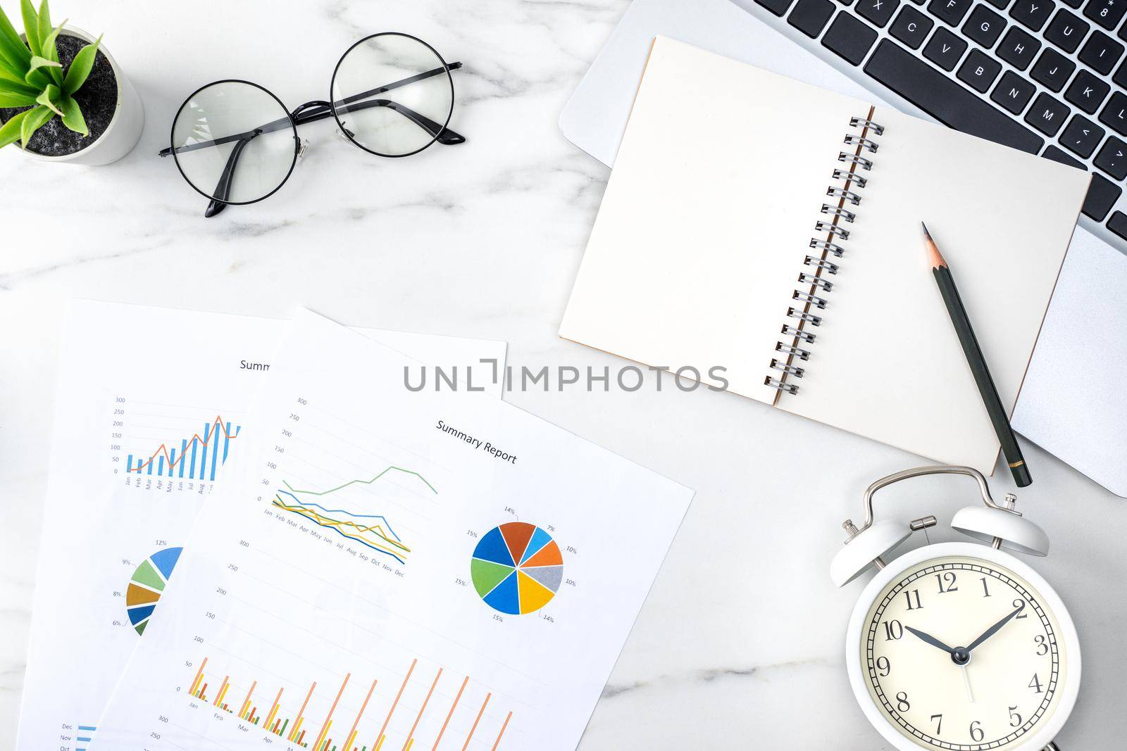 Top view of office table desk work concept with blank notebook, report, alarm clock on marble white background, concept of timing management and schedule planning.