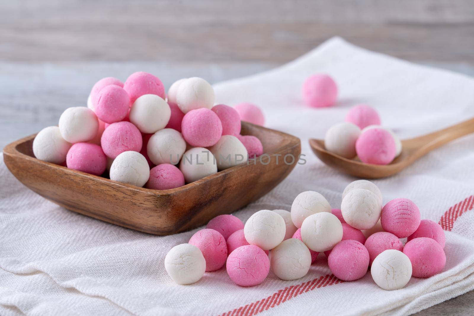 Raw red and white tangyuan glutinous rice dumpling balls on wooden table background for Winter solstice festival food.