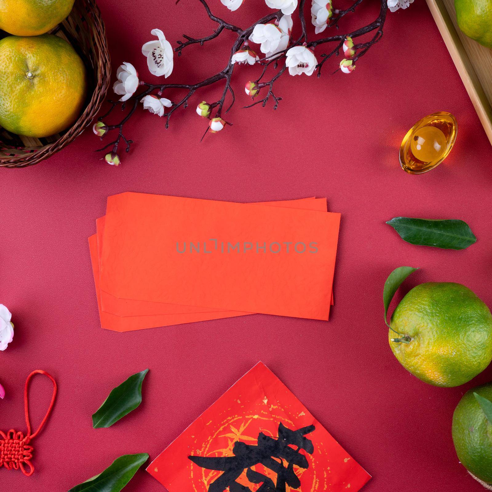 Top view of fresh ripe tangerine mandarin orange with fresh leaves on red table background for Chinese lunar new year fruit concept, the Chinese word means spring.