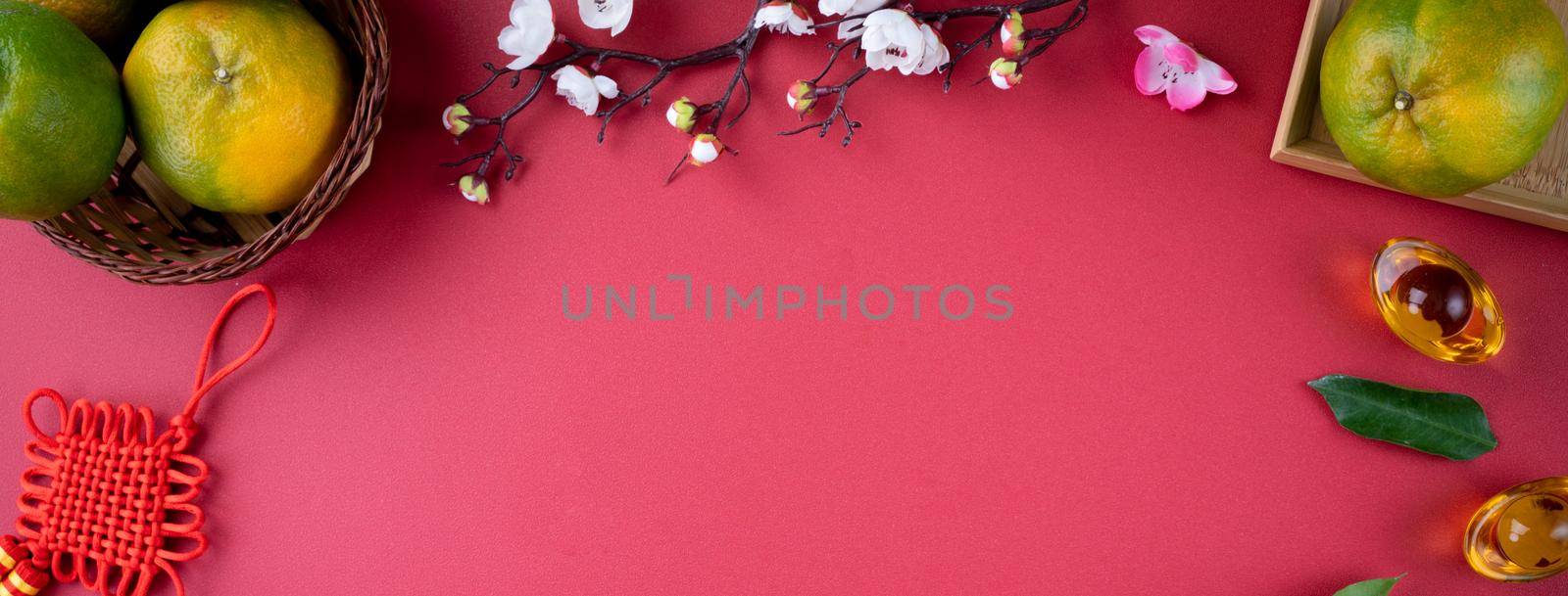 Top view of fresh ripe tangerine mandarin orange with fresh leaves on red table background for Chinese lunar new year fruit concept, the Chinese word means spring.