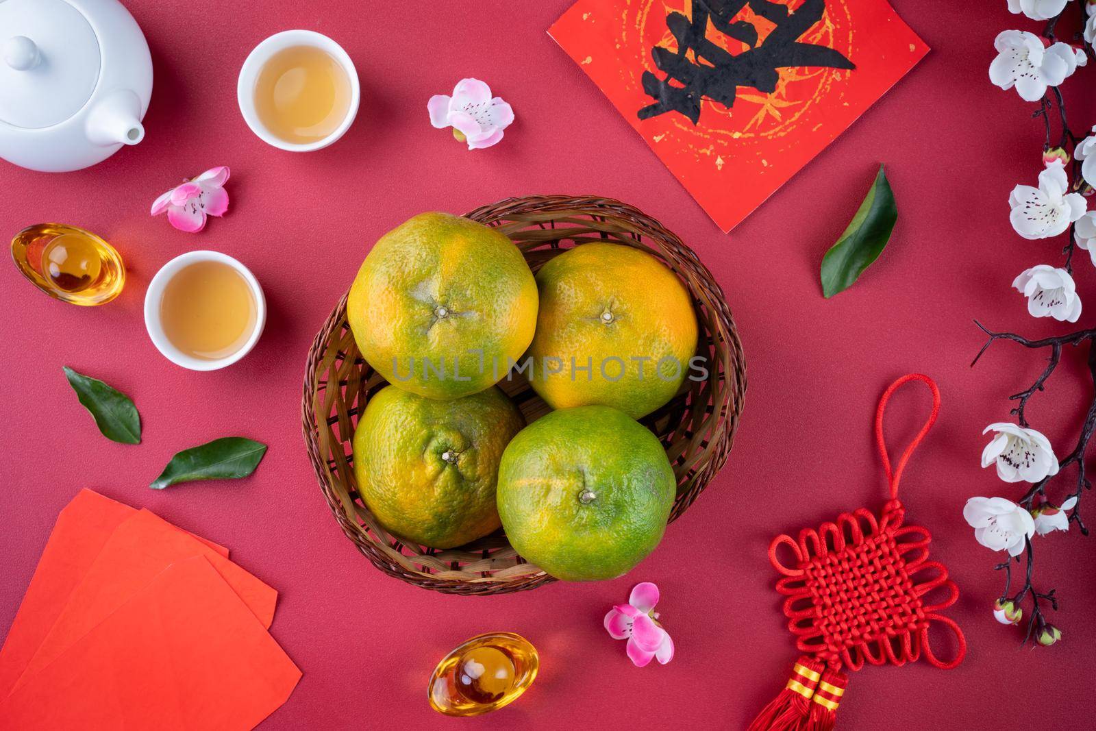 Top view of fresh ripe tangerine mandarin orange with fresh leaves on red table background for Chinese lunar new year fruit concept, the Chinese word means spring.