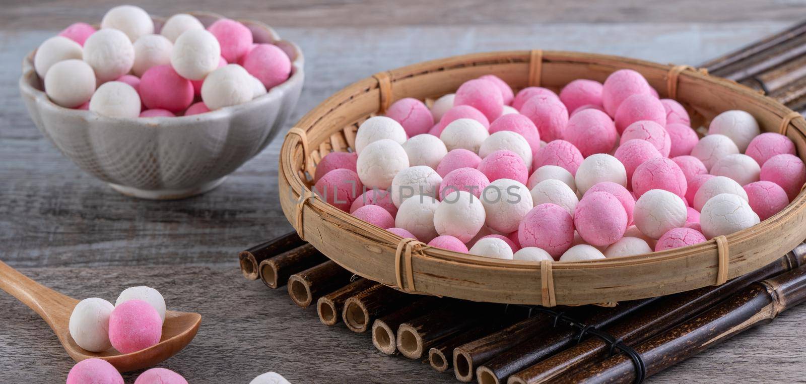 Raw red and white tangyuan glutinous rice dumpling balls on wooden table background for Winter solstice festival food.