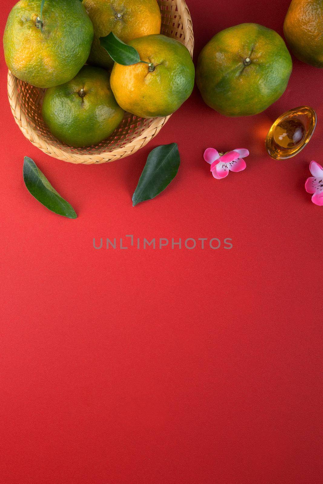 Top view of fresh ripe tangerine mandarin orange with fresh leaves on red table background for Chinese lunar new year fruit concept, the Chinese word means spring.