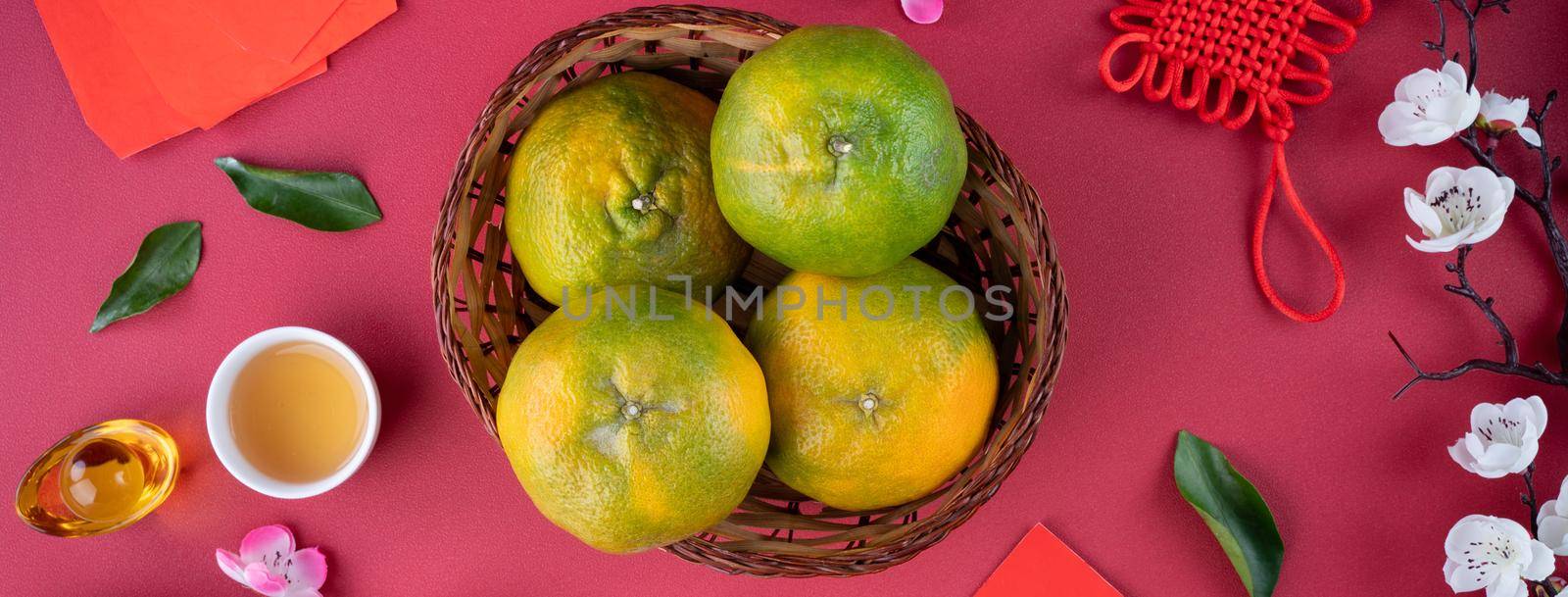 Top view of fresh ripe tangerine mandarin orange with fresh leaves on red table background for Chinese lunar new year fruit concept, the Chinese word means spring.