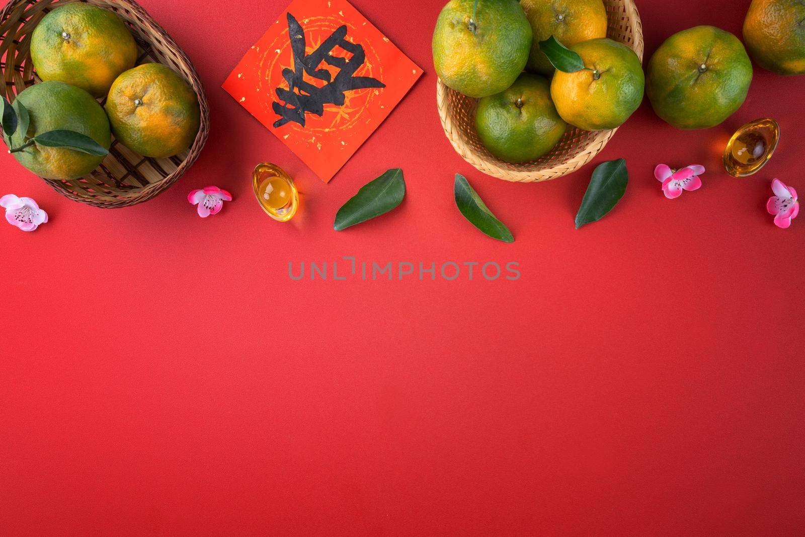 Top view of fresh ripe tangerine mandarin orange with fresh leaves on red table background for Chinese lunar new year fruit concept, the Chinese word means spring.