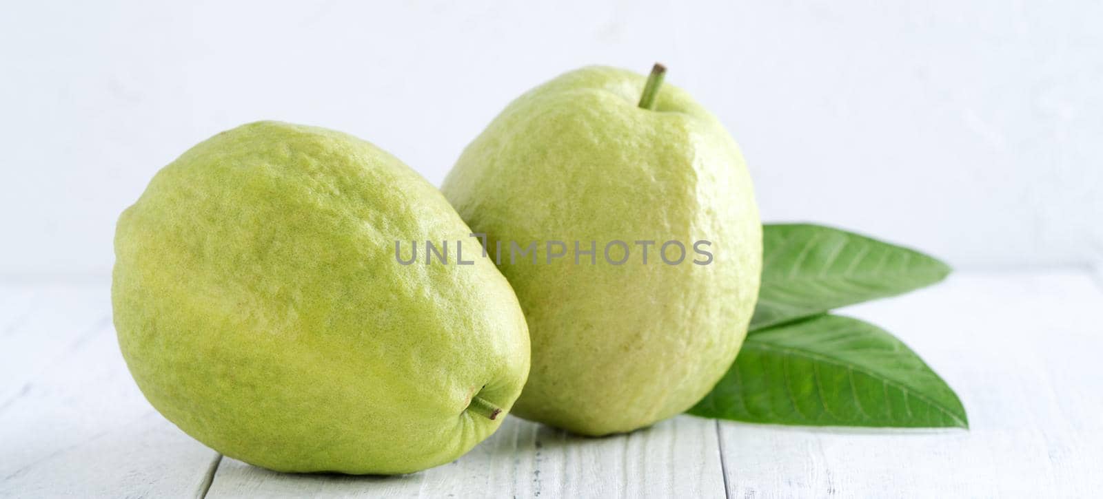 Close up of delicious beautiful Red guava with fresh green leaves isolated on white table background, studio table shot with copy space.