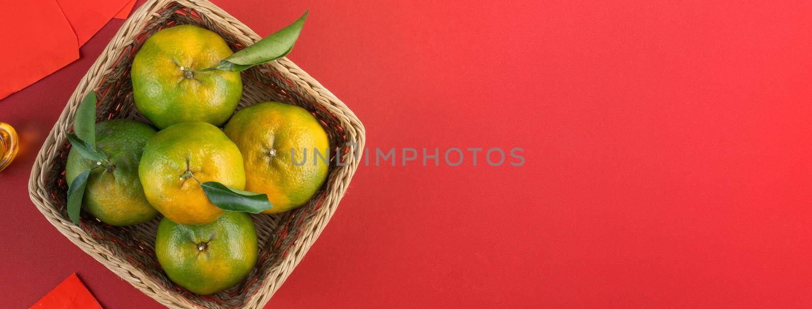 Top view of fresh ripe tangerine mandarin orange with fresh leaves on red table background for Chinese lunar new year fruit concept, the Chinese word means spring.