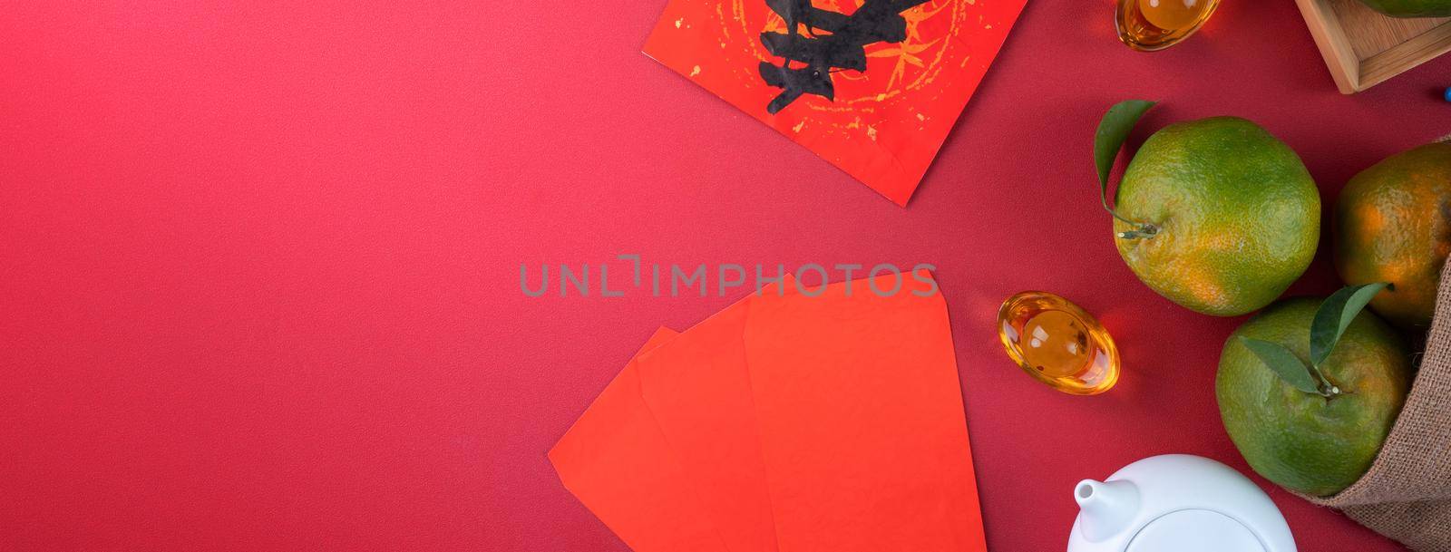 Top view of fresh ripe tangerine mandarin orange with fresh leaves on red table background for Chinese lunar new year fruit concept, the Chinese word means spring.
