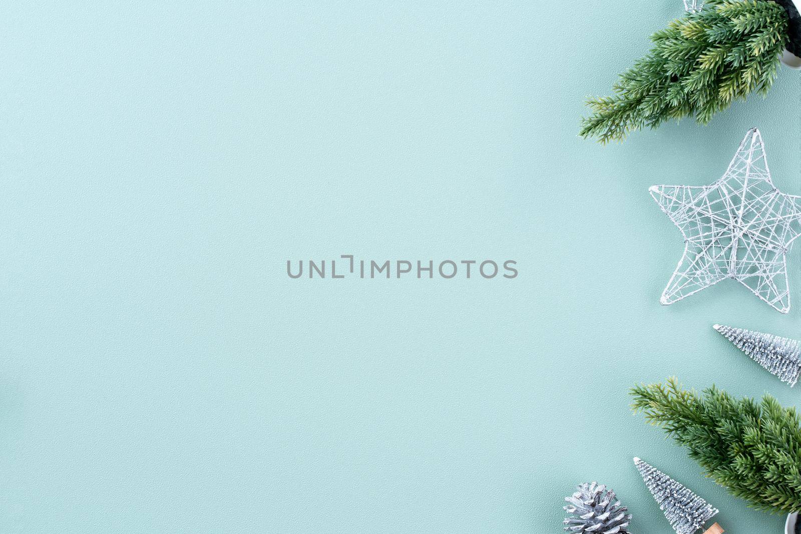 Top view of Christmas holiday decoration ornament composition with Christmas tree, gift star, gingerbread man flat lay with copy space isolated on green background.