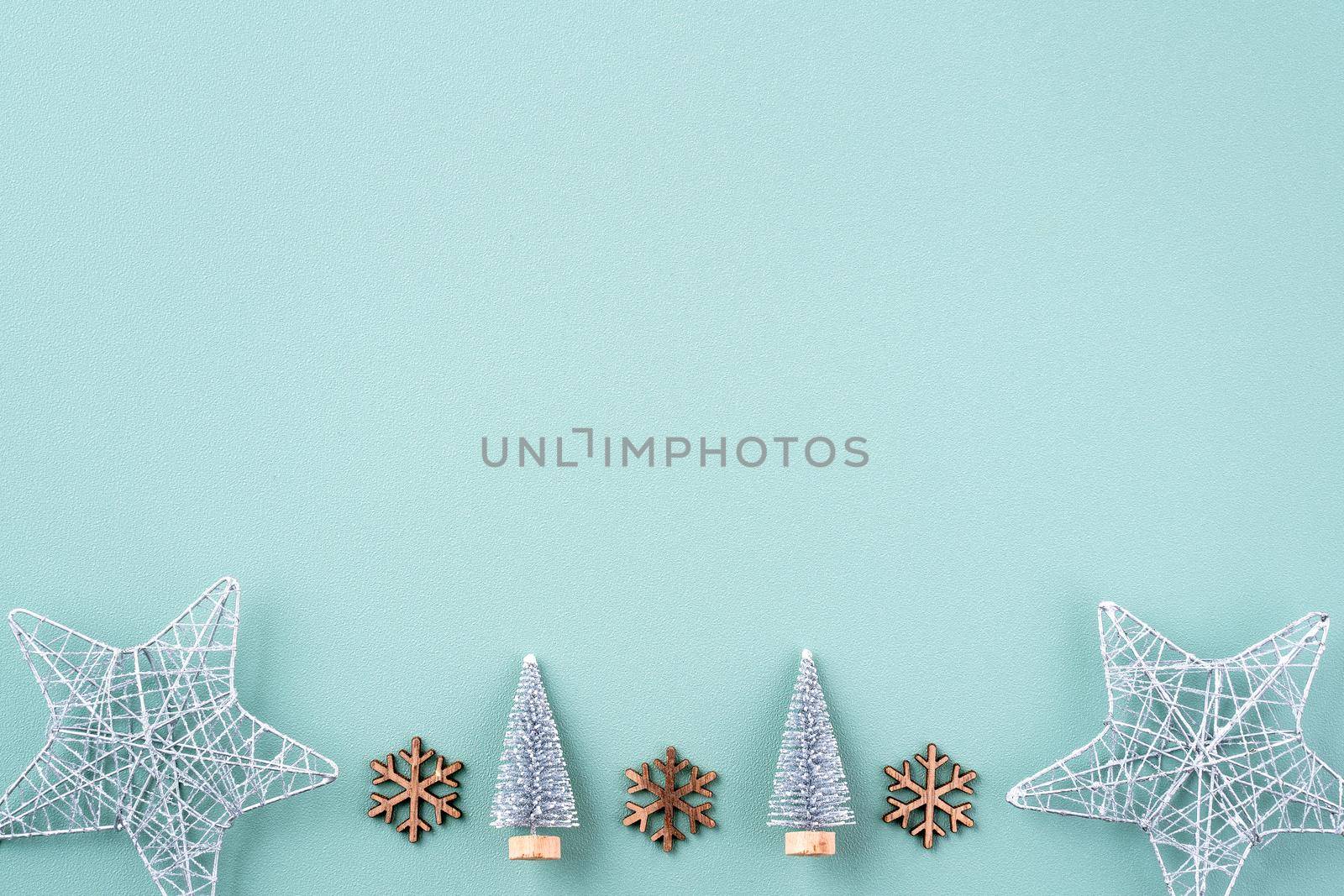 Top view of Christmas holiday decoration ornament composition with Christmas tree, gift star, gingerbread man flat lay with copy space isolated on green background.
