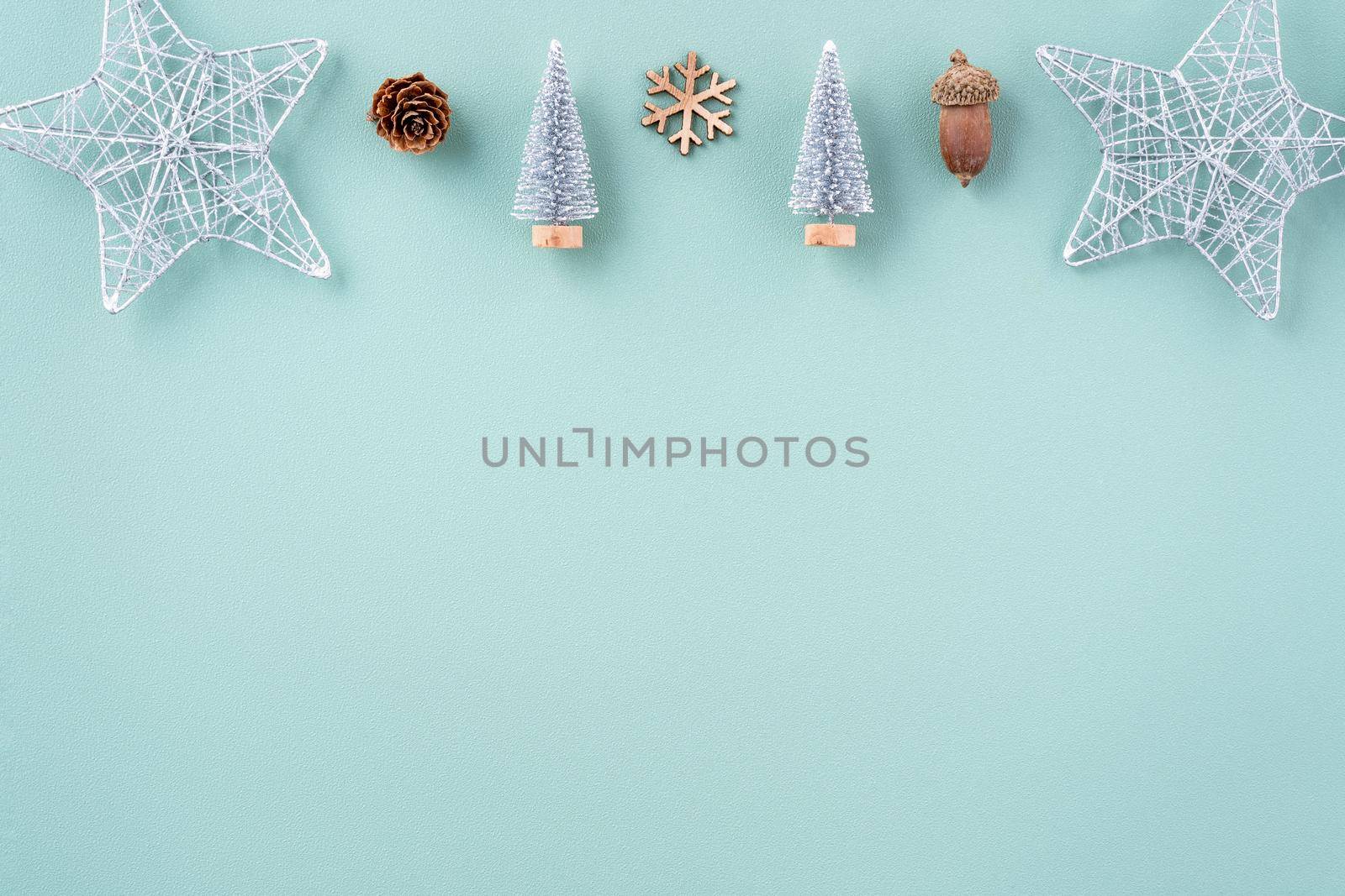 Top view of Christmas holiday decoration ornament composition with Christmas tree, gift star, gingerbread man flat lay with copy space isolated on green background.