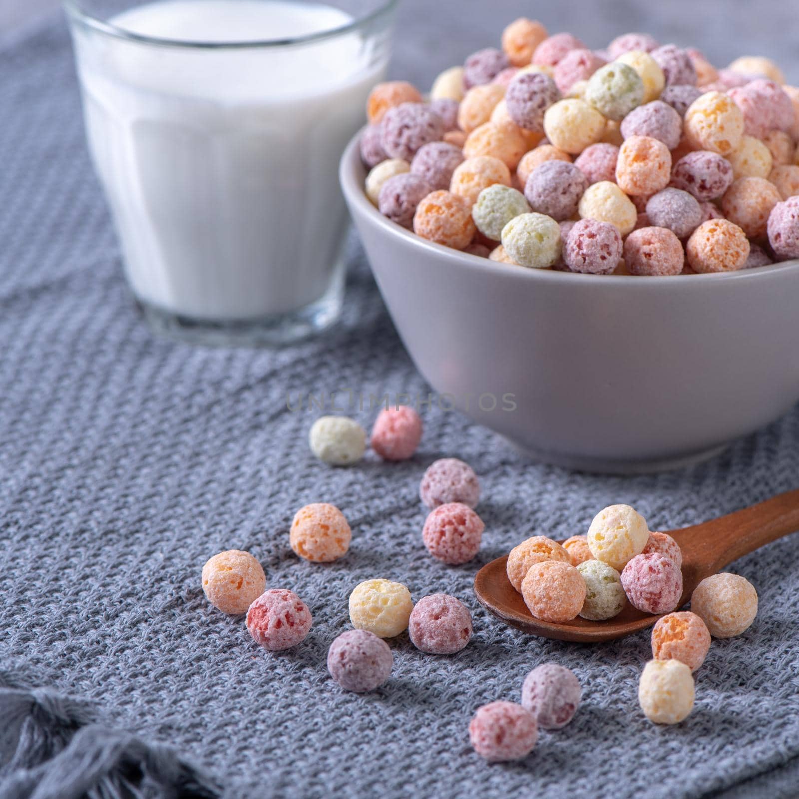 Colorful cereal corn balls mix, fruit flavor bowl sweets on gray cement background, close up, fresh, delicious and healthy breakfast, copy space design concept.