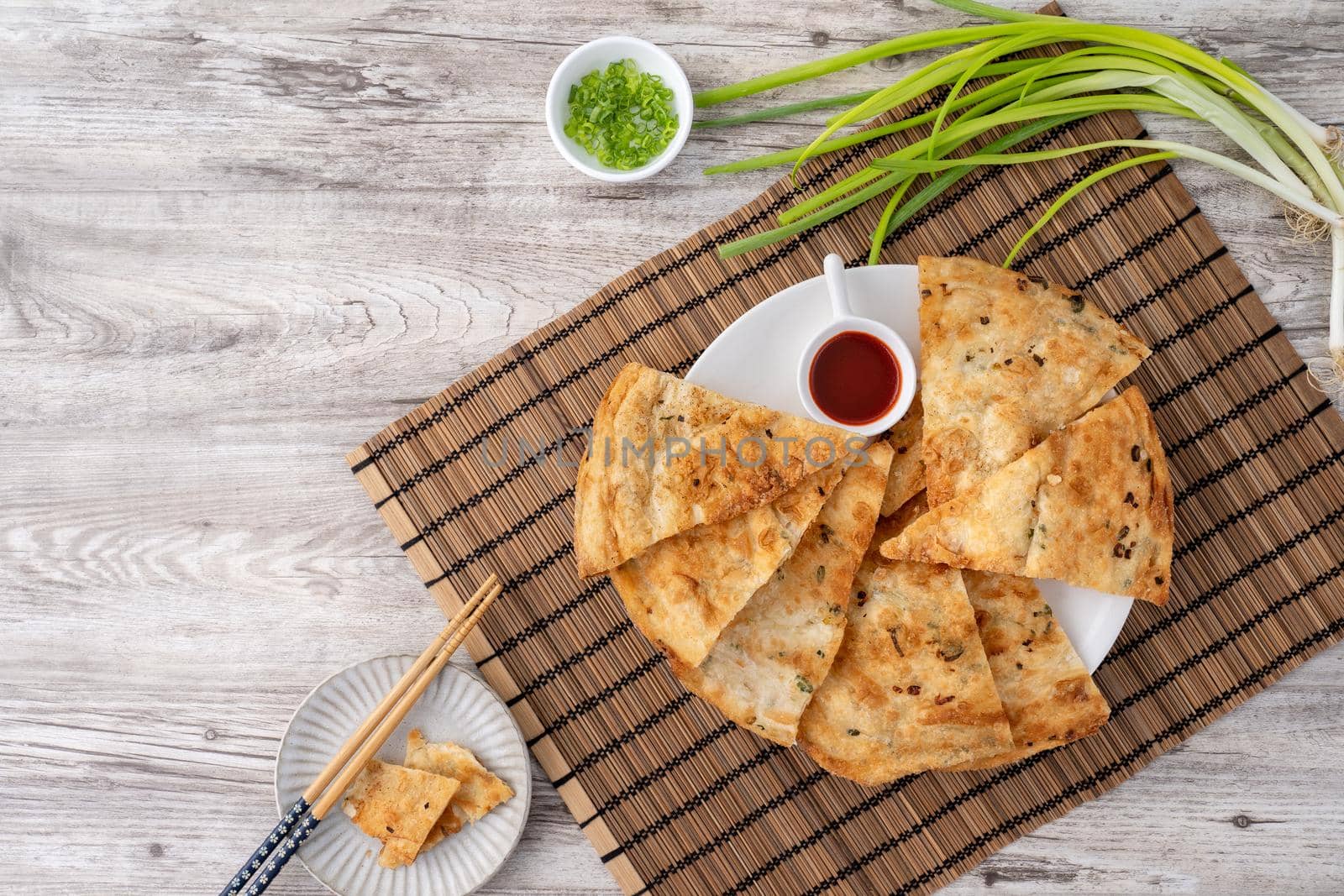 Taiwanese food - delicious flaky scallion pie pancakes on bright wooden table background, traditional snack in Taiwan, top view.