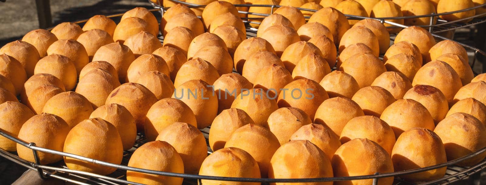 Making process of sun exposuring drying peeled dried persimmon in a sieve, autumn preserved food concept.