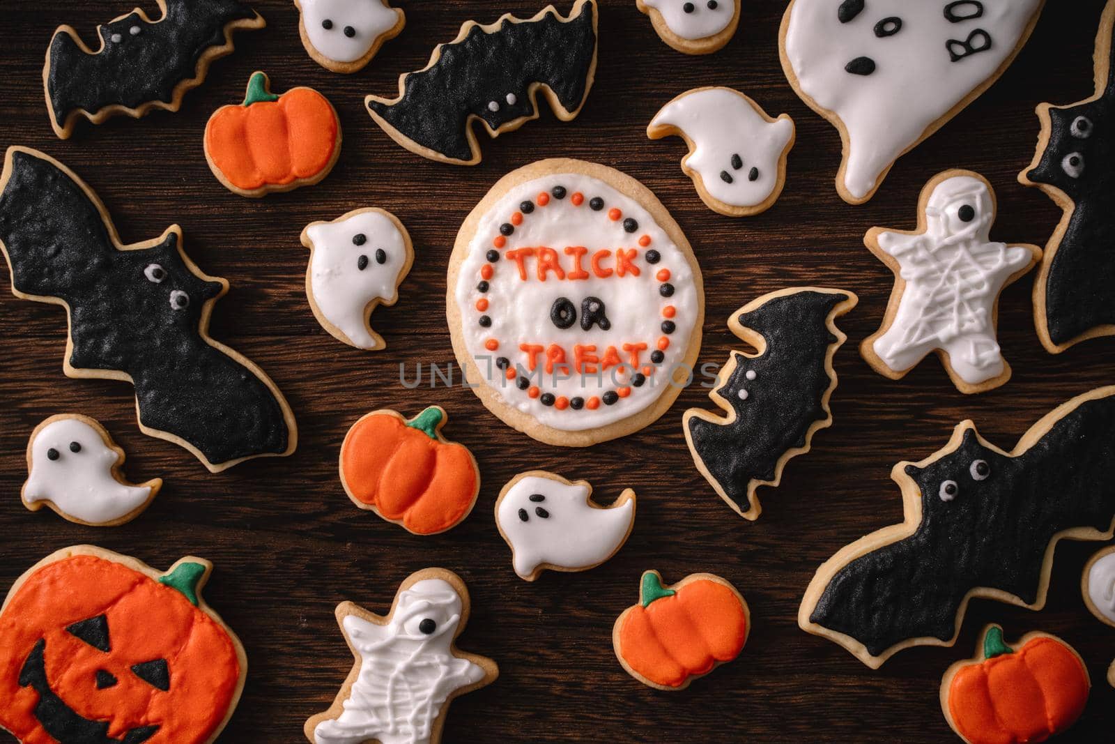 Top view of Halloween festive decorated icing gingerbread sugar cookies with copy space and flat lay layout.