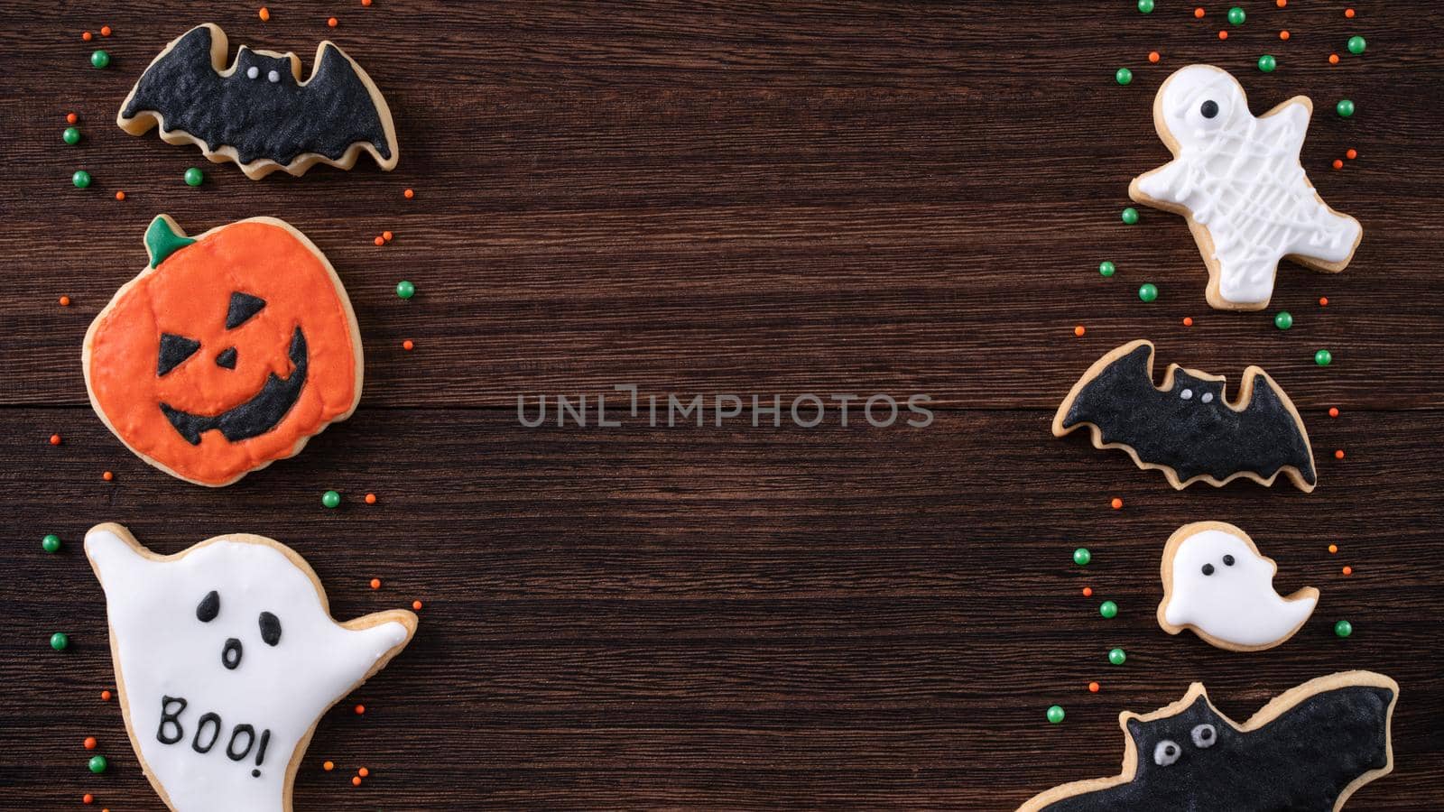 Top view of Halloween festive decorated icing gingerbread sugar cookies with copy space and flat lay layout.