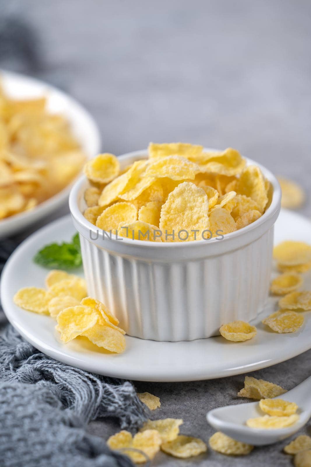 Corn flakes bowl sweeties with milk on gray cement background, close up, fresh and healthy breakfast design concept.