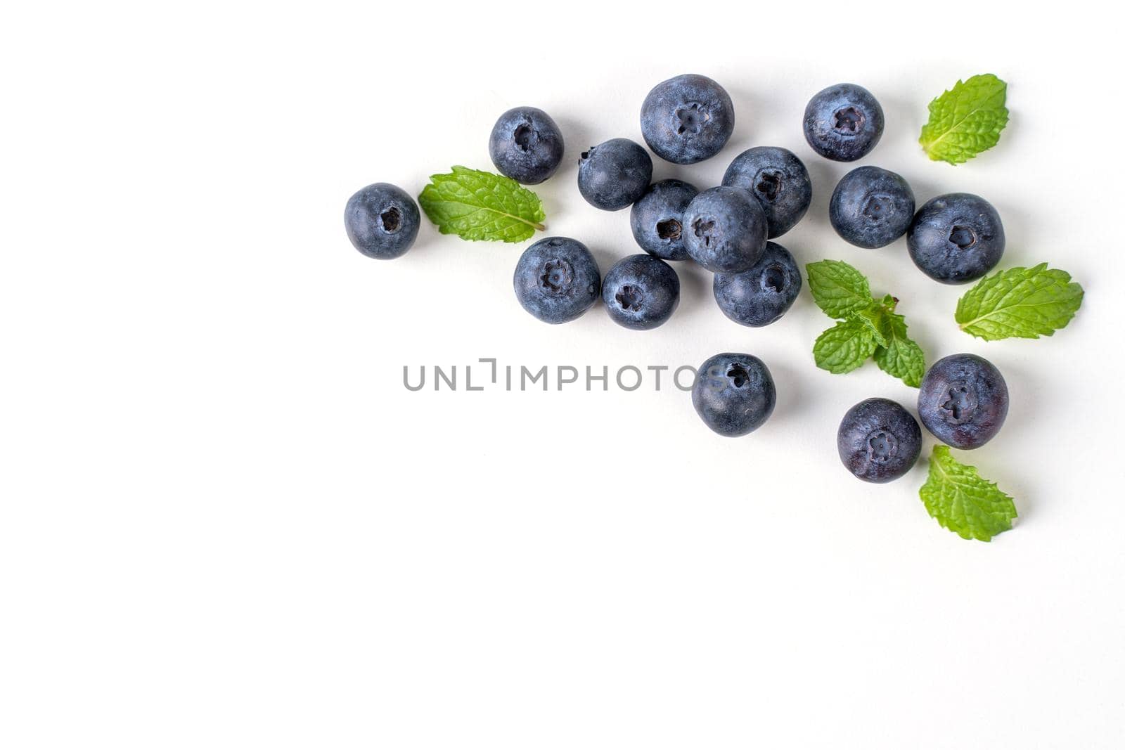Blueberry fruit top view isolated on a white background, flat lay overhead layout with mint leaf, healthy design concept.