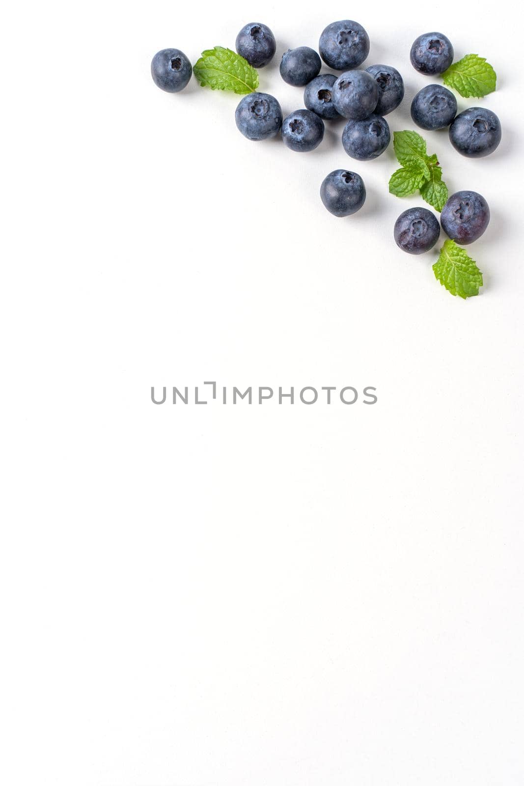 Blueberry fruit top view isolated on a white background, flat lay overhead layout with mint leaf, healthy design concept.