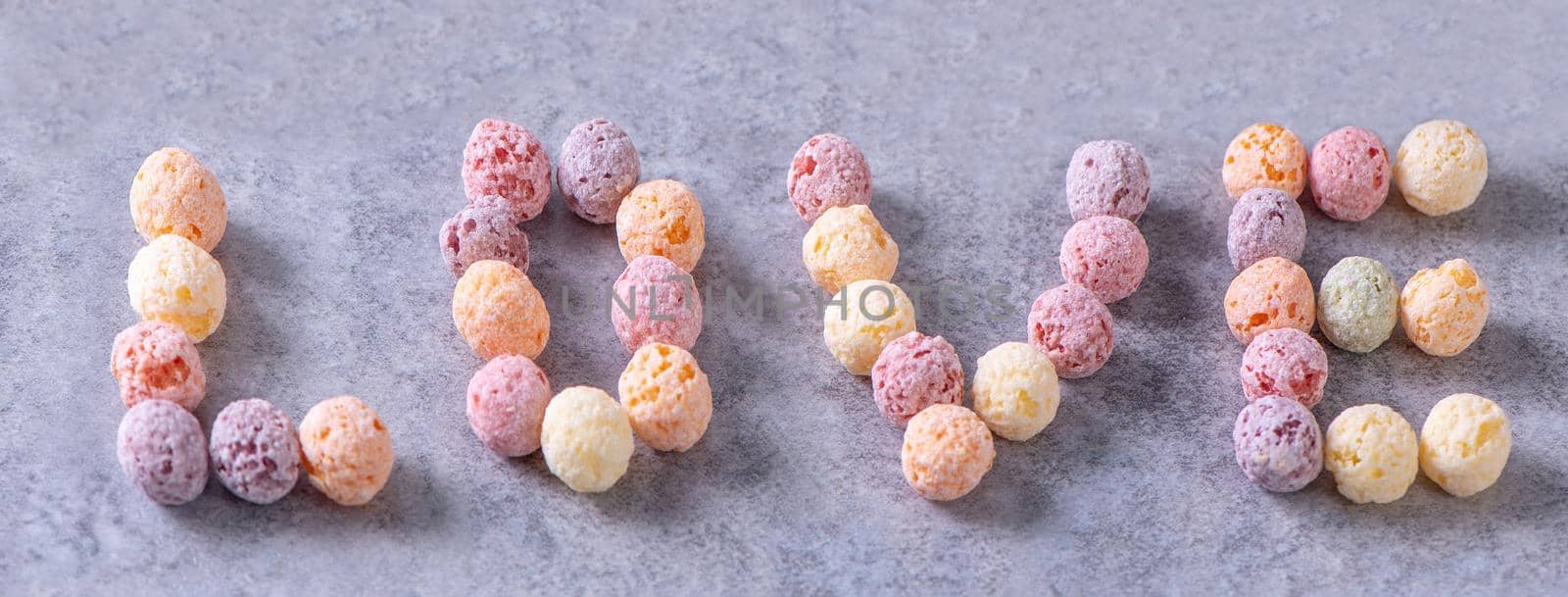 Colorful cereal corn balls mix, fruit flavor bowl sweets on gray cement background, close up, fresh, delicious and healthy breakfast, copy space design concept.