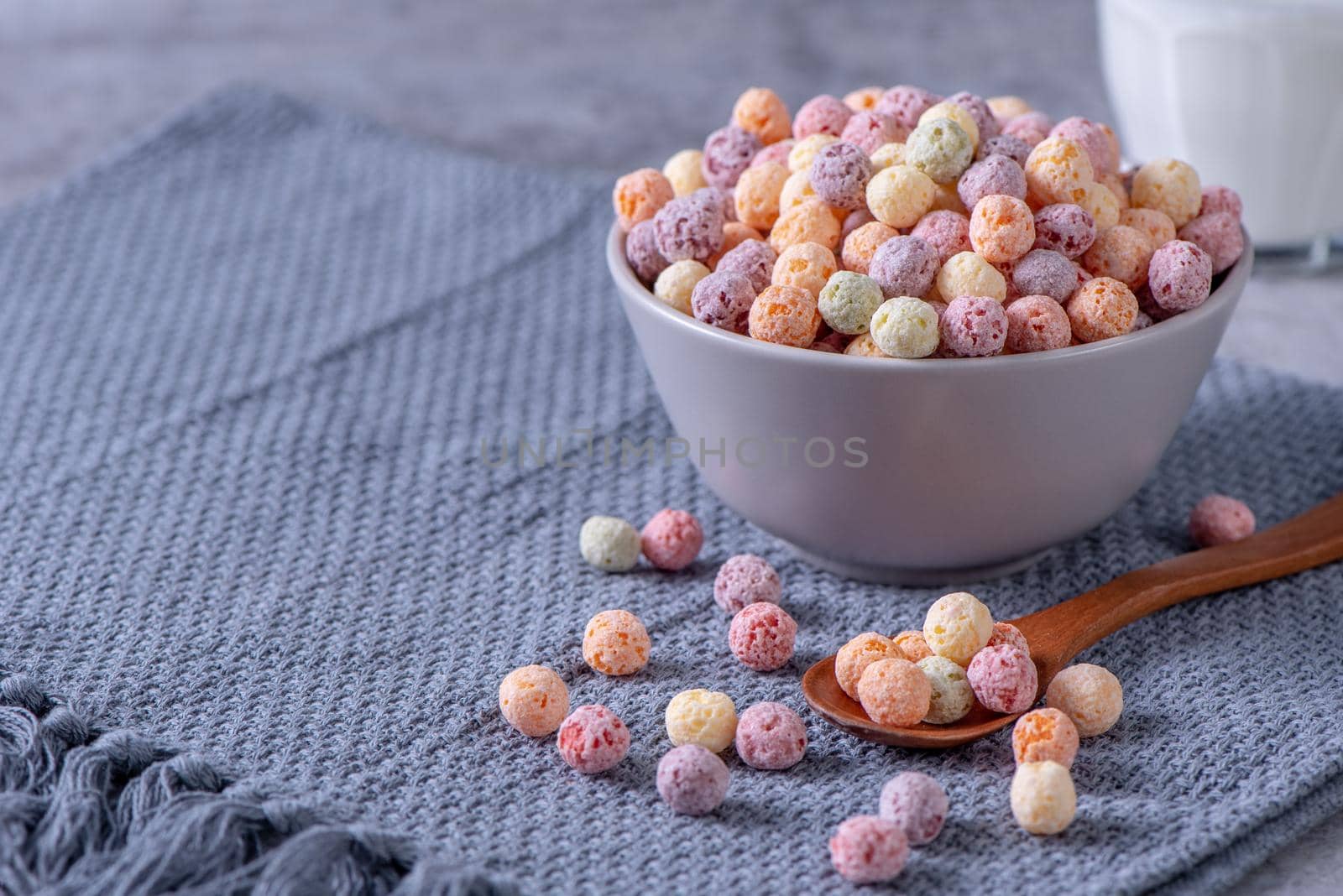 Colorful cereal corn balls mix, fruit flavor bowl sweets on gray cement background, close up, fresh, delicious and healthy breakfast, copy space design concept.