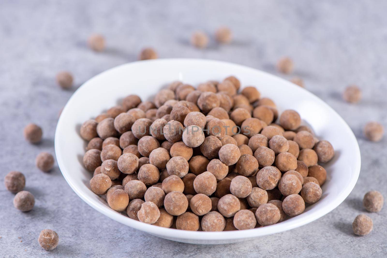 Dry raw brown tapioca pearls isolated on gray cement concrete background, close up, ingredient of making bubble boba tapioca milk tea.
