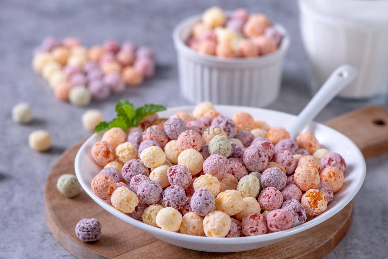 Colorful cereal corn balls mix, fruit flavor bowl sweets on gray cement background, close up, fresh, delicious and healthy breakfast, copy space design concept.