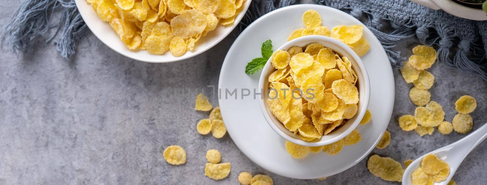 Corn flakes bowl sweets on gray cement background, top view flat lay layout design, fresh and healthy breakbast concept.
