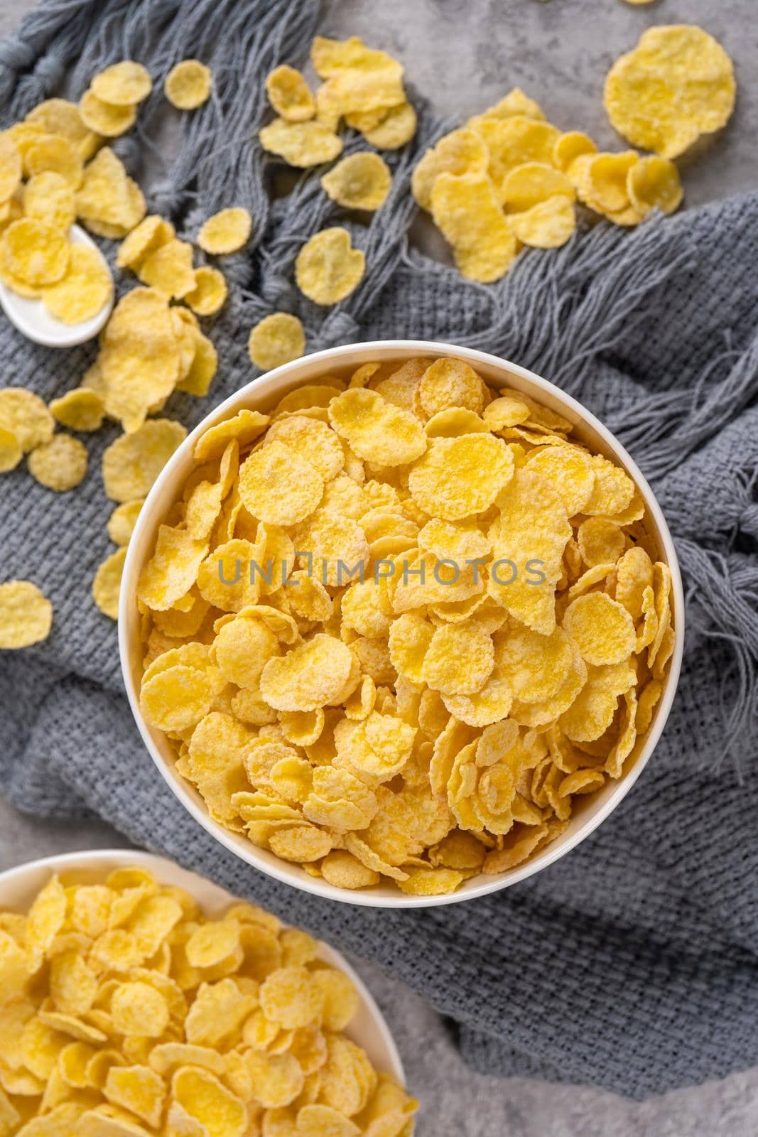 Corn flakes bowl sweets on gray cement background, top view flat lay layout design, fresh and healthy breakbast concept. by ROMIXIMAGE