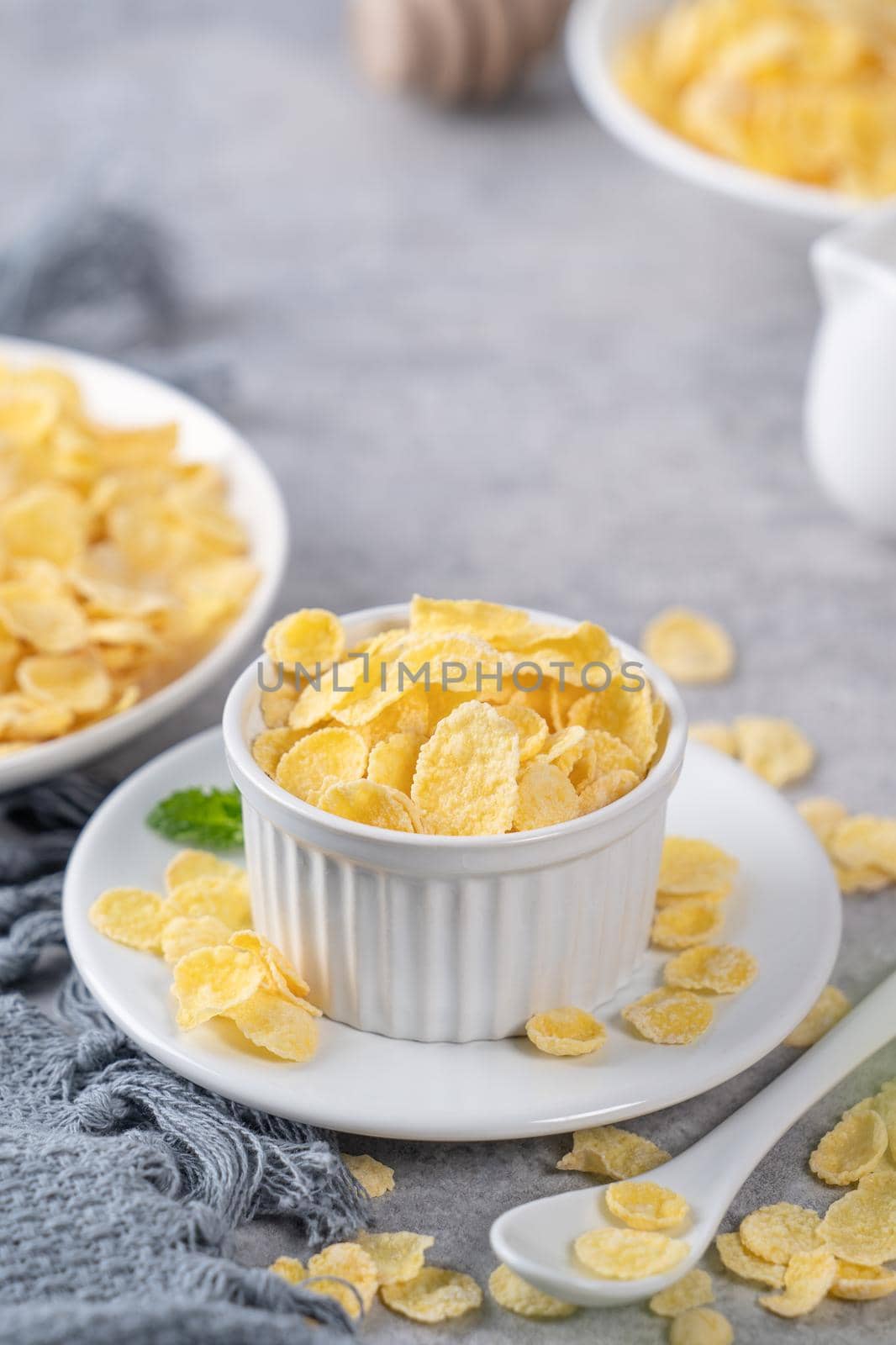 Corn flakes bowl sweeties with milk on gray cement background, close up, fresh and healthy breakbast design concept.